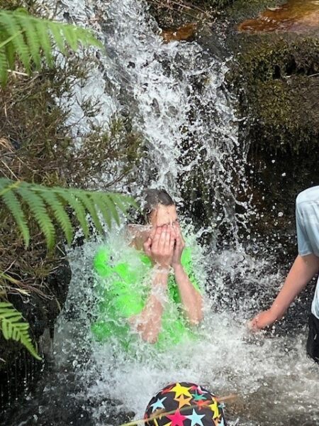 student under waterfall