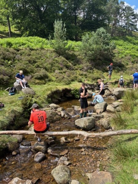 students relaxing by stepping stones