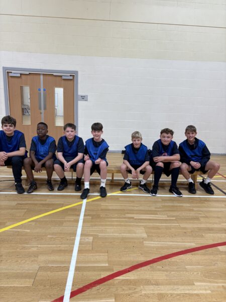 Year 7 boys sitting on bench in gym
