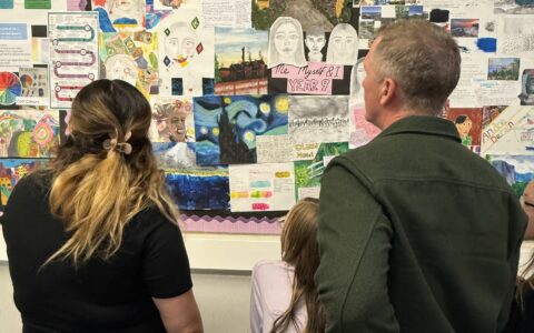 art teacher showing parent and child some artwork