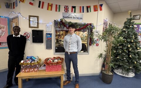 sixth form male students next to food bank donation boxes in sixth form common room