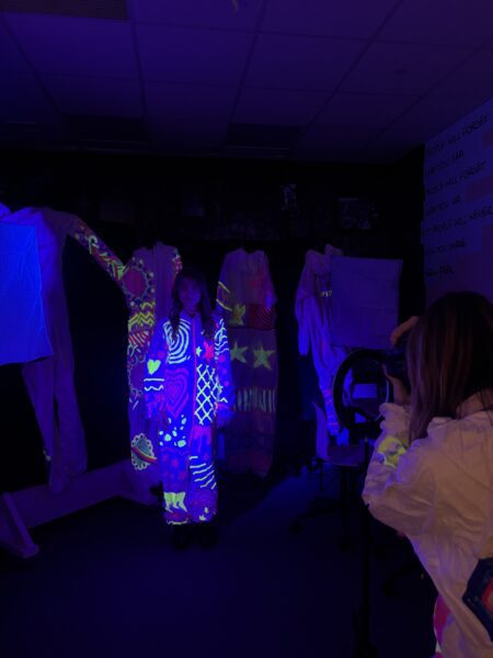 post 16 female student in neon suit in photography room